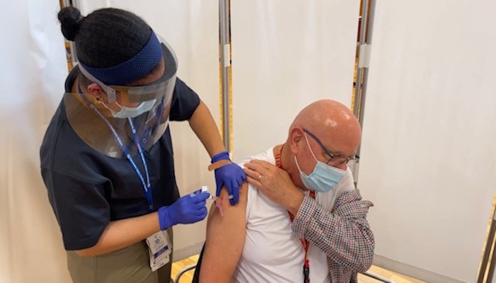 Dr. John Nadeau receiving the Moderna COVID-19 vaccine
