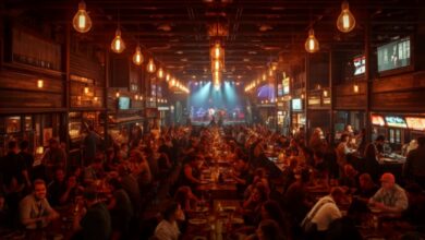 Bustling interior of Assembly Food Hall in downtown Nashville at night, with glowing food stalls, communal tables, string lights and a live-music stage