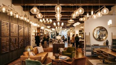 Interior of the Rejuvenation lighting and hardware showroom at Hill Center Green Hills in Nashville, with vintage-inspired pendant lamps and chandeliers glowing overhead