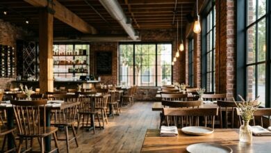 A quiet upscale Southern dining room in a converted brick warehouse, empty tables in late-afternoon light