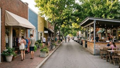 A walkable 12 South style Nashville shopping street with brick storefronts, awnings and an open-air covered market stall area (illustrative)