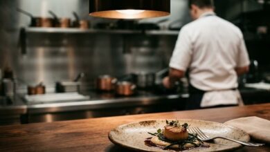 Plated tasting-menu course on a chef's counter in an intimate fine-dining restaurant with an open kitchen behind (illustrative)