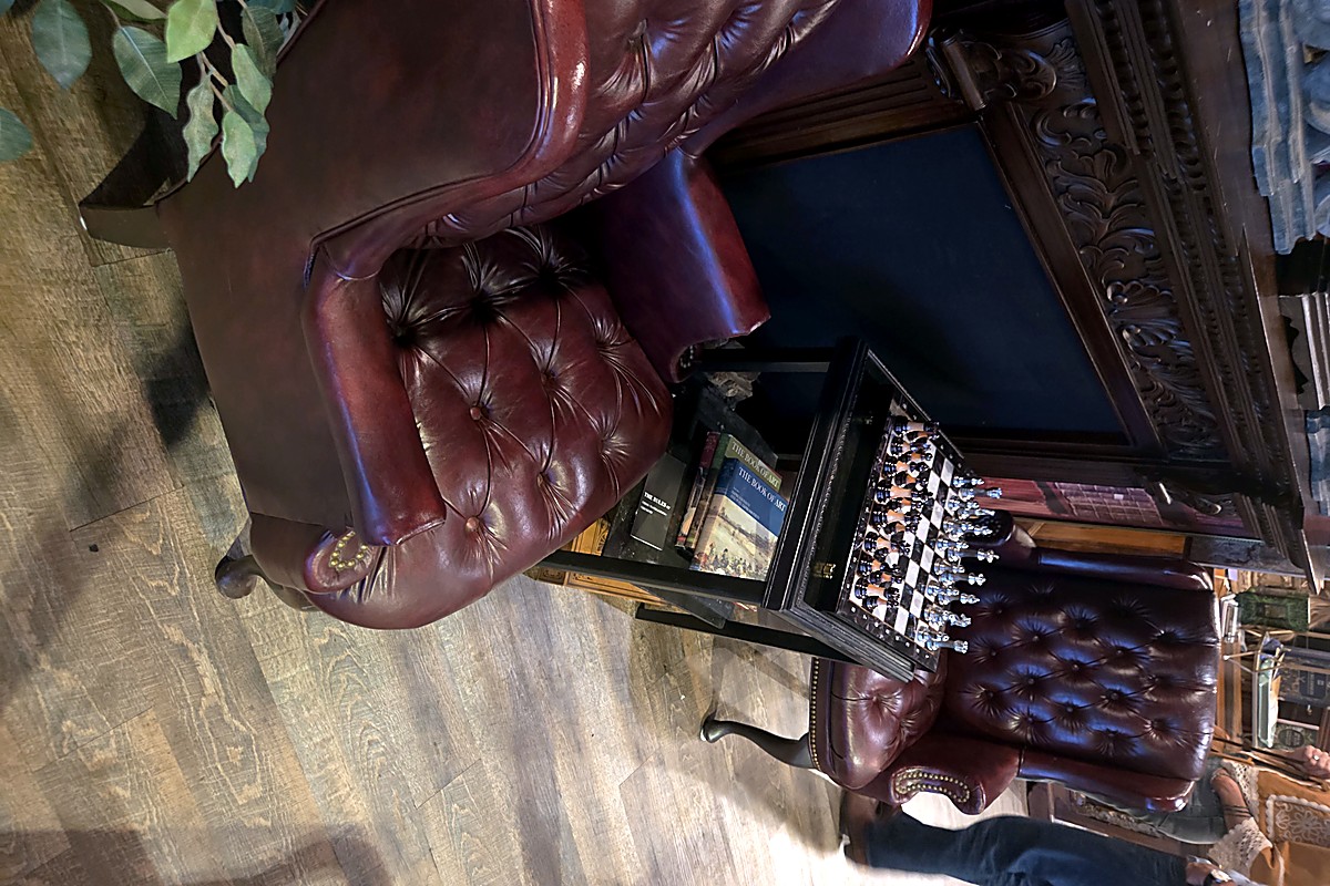 Tufted leather reading chairs and a chess set at The Raven Book Lounge