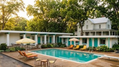 Restored mid-century roadside motel wing wrapping a swimming pool at golden hour with an older clapboard house beyond, illustrating Salt Ranch on Dickerson Pike in East Nashville (illustrative)