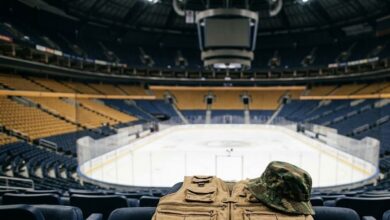 Fishing vest and camo bucket hat on a seat in an empty hockey arena (illustrative)